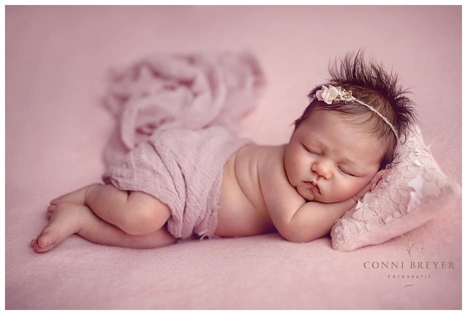 Baby Fotografie in schöner Pose in zartrosa und schönem Stirnbändchen - conni breyer fotografin