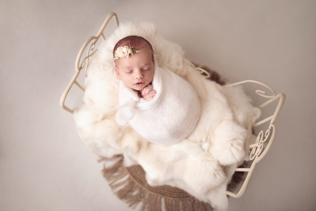 Süßes Baby Mädchen mit Haarband in zeitlosem creme Newbornshooting bei Conni Breyer Fotografie nähe Memmingen